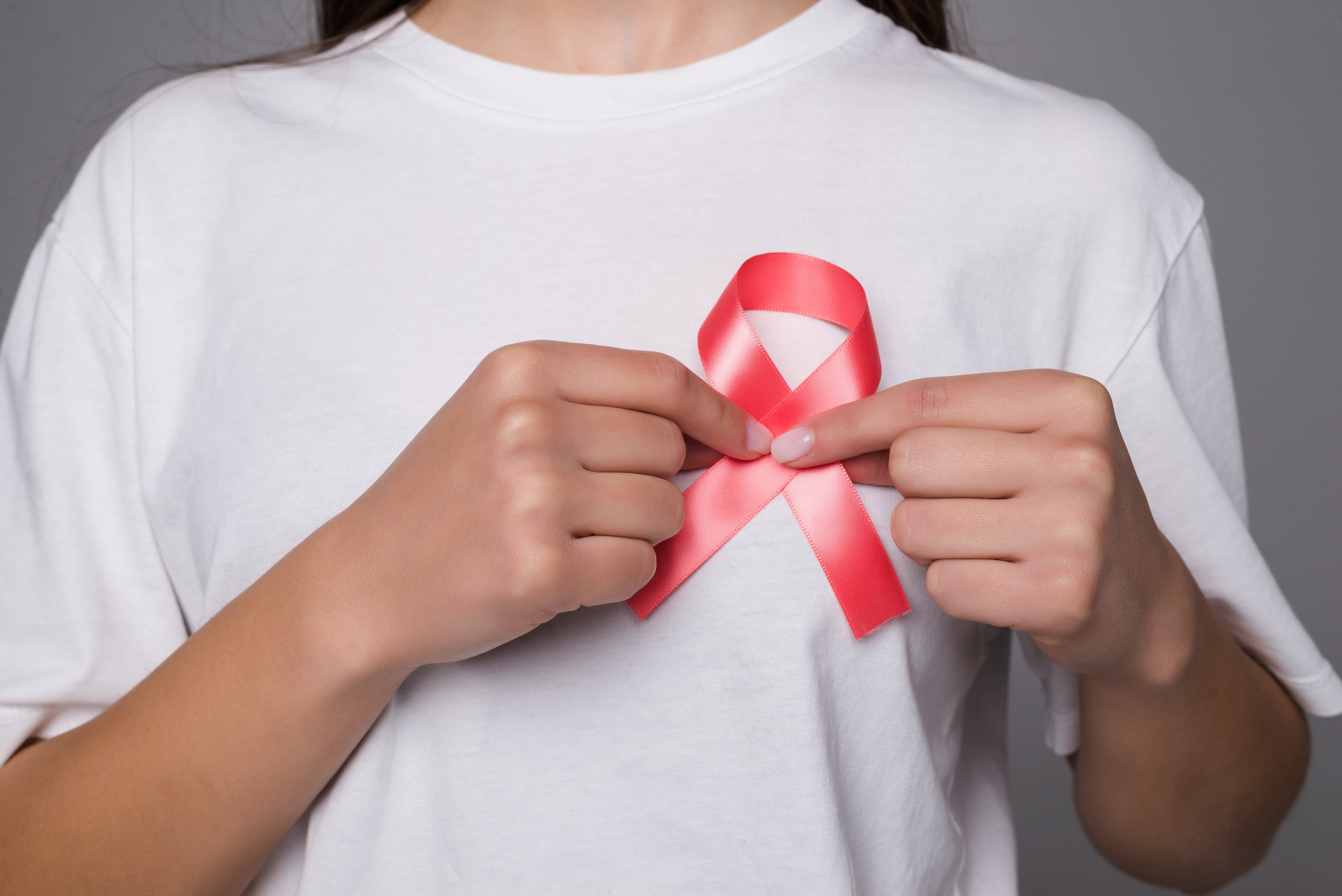world-breast-cancer-day-concept-health-care-woman-wore-white-t-shirt-with-pink-ribbon-awareness-symbolic-bow-color-raising-people-living-with-women-s-breast-tumor-illness